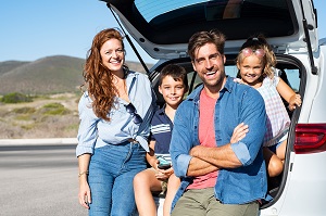 family sitting in trunk of suv