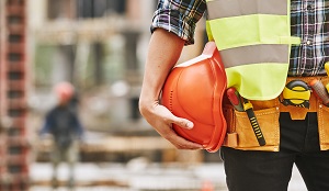 construction worker holding orange hard hat